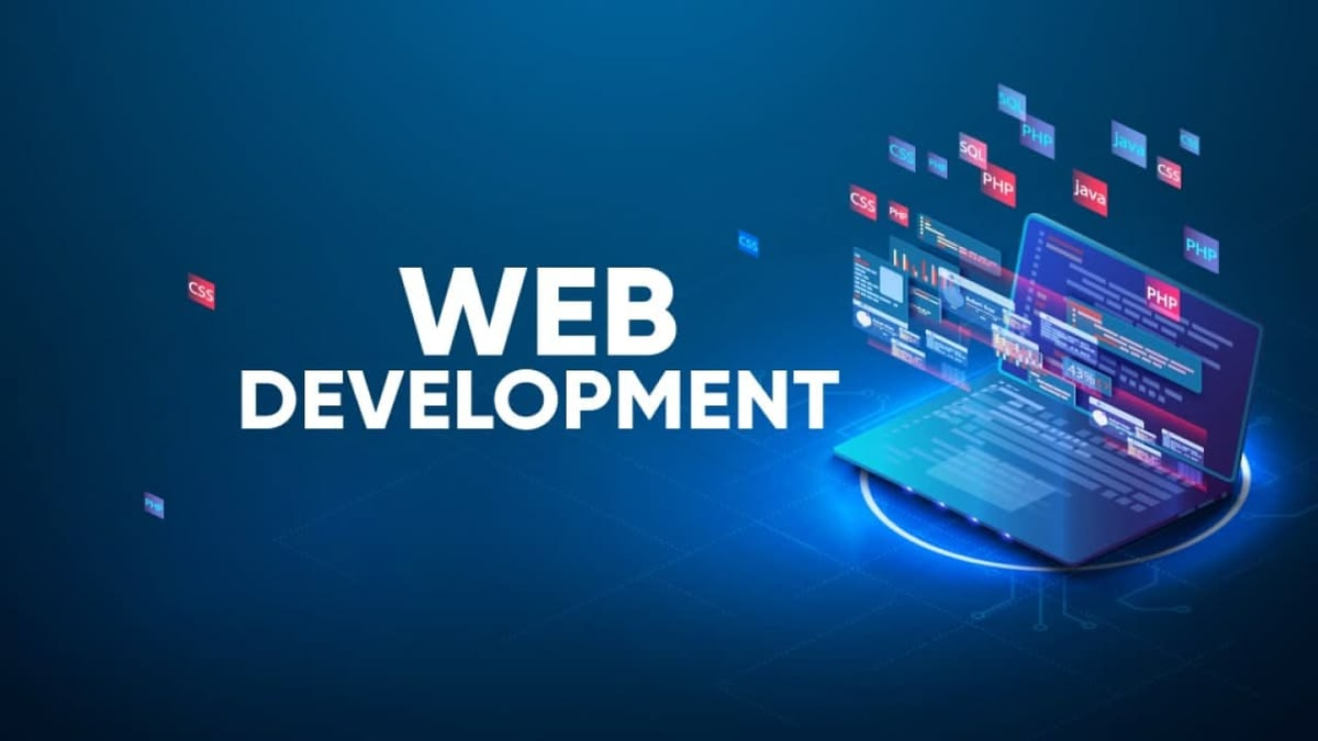 Web developer working on a laptop with a code editor open, surrounded by design tools and documentation
