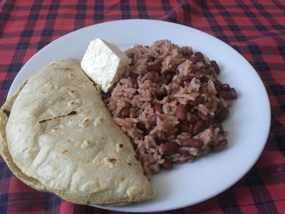 Plato de Gallo Pinto nicaragüense con queso frito y plátano maduro