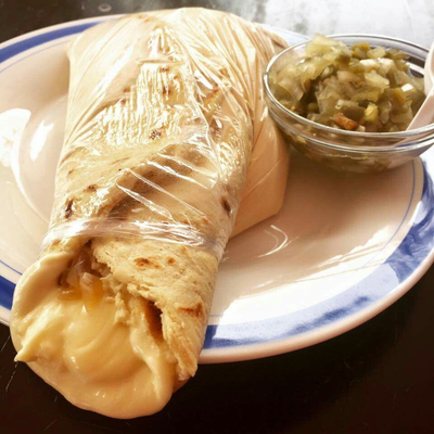 Quesillo envuelto en bolsa con crema y cebolla encurtida
