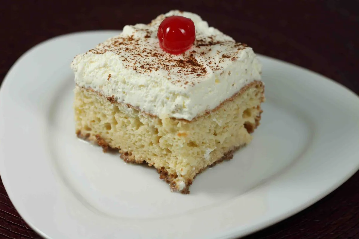 Porción de pastel Tres Leches con merengue y cereza