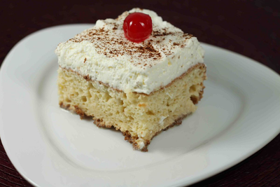 Porción de pastel Tres Leches con merengue y cereza