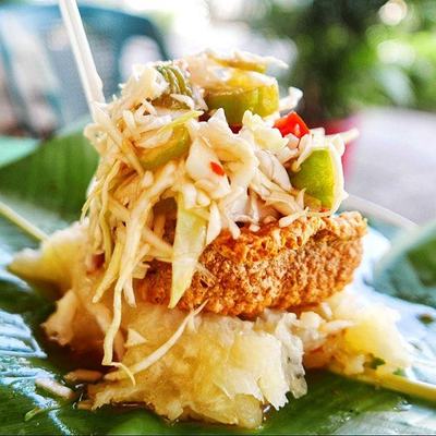 Vigorón servido sobre hoja de plátano con chicharrón y ensalada de repollo